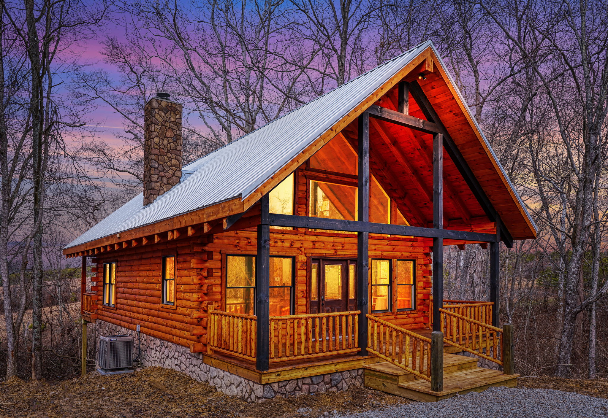 Bluebonnet Luxury Cabin lit at dusk among the trees in the Hocking Hills