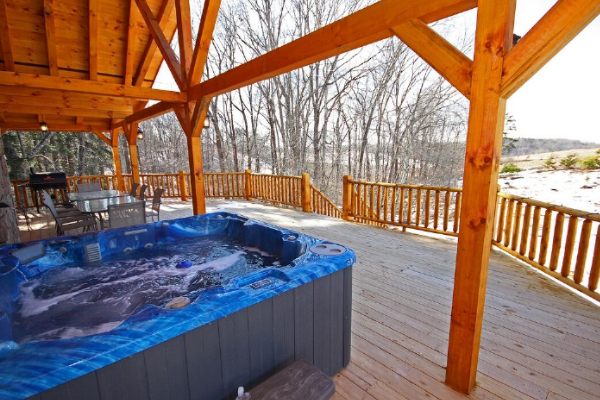 Closeup of Hot Tub 1, on West side porch looking Southwest, with Trees and Rolling Hills in background. The charcoal grill is at opposite end of porch