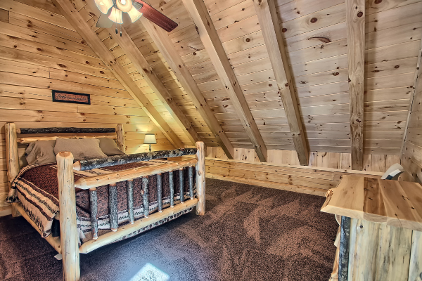 Private Bedroom 5, on Loft Level, with Log Queen Bed, Log Nightstand with lamp, and Log Dresser, Carpet Flooring  and Ceiling Fan