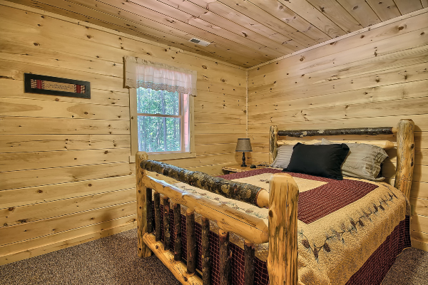 Lower Level Private Bedroom 1, showing Log Queen Bed, Log Night Stand and Window. Carpet Flooring