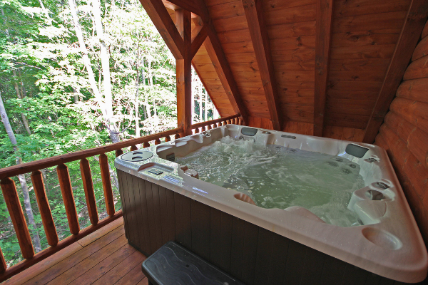 Closeup of Hot Tub 2, on the Loft Level Covered Porch, with Log Railings and Woods on left