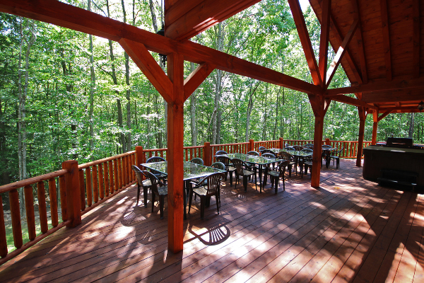 Southwest end of Lodge, on Wrap-Around Deck, with Cathedral Ceiling, 4 Tables with chairs around, as well as Hot Tub 1 on Northwest end of Deck.