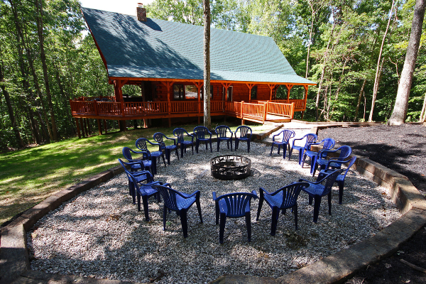 Closeup of Large Fire pit area in front of lodge, with 18 Chairs and Landscaping